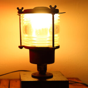 Original skibslanterne i kobber og messing fra grønlandsk krabbebåd – ombygget til moderne brug med synlig glaslinse hele vejen rundt.