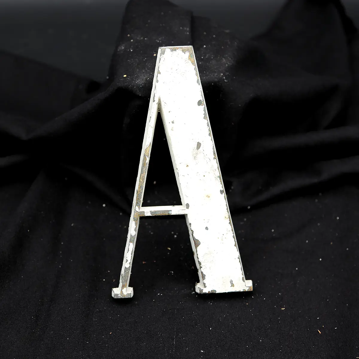 Overmalet messing-facadebogstav “A” med rå patina og originale gevindstænger.