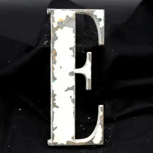 Overmalet messing-facadebogstav “E” med rå patina og originale gevindstænger.