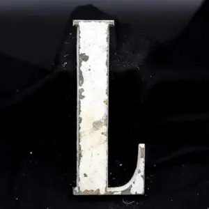 Overmalet messing-facadebogstav “L” med rå patina og originale gevindstænger.