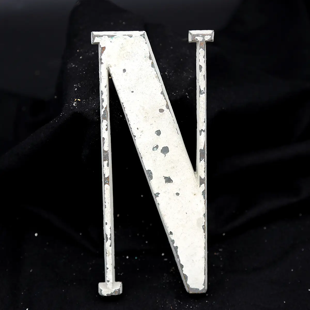 Overmalet messing-facadebogstav “N” med rå patina og originale gevindstænger.