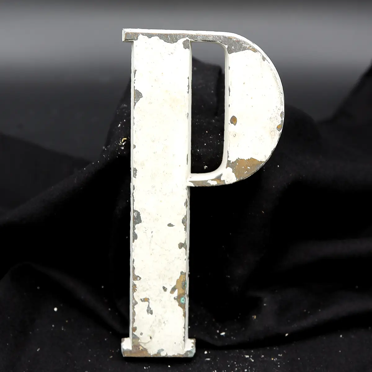 Overmalet messing-facadebogstav “P” med rå patina og originale gevindstænger.