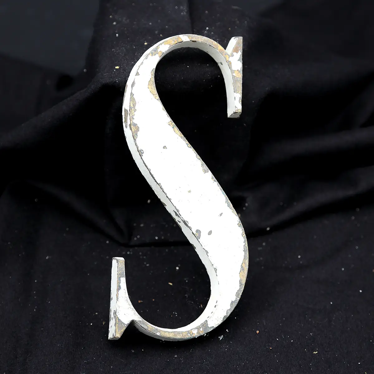 Overmalet messing-facadebogstav “S” med rå patina, afskallet maling og originale gevindstænger.