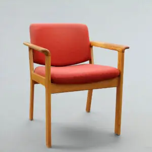 Erik Kirkegaard armstol i massiv eg for Høng Stolefabrik med rødorange polstring og smuk, naturlig patina.
