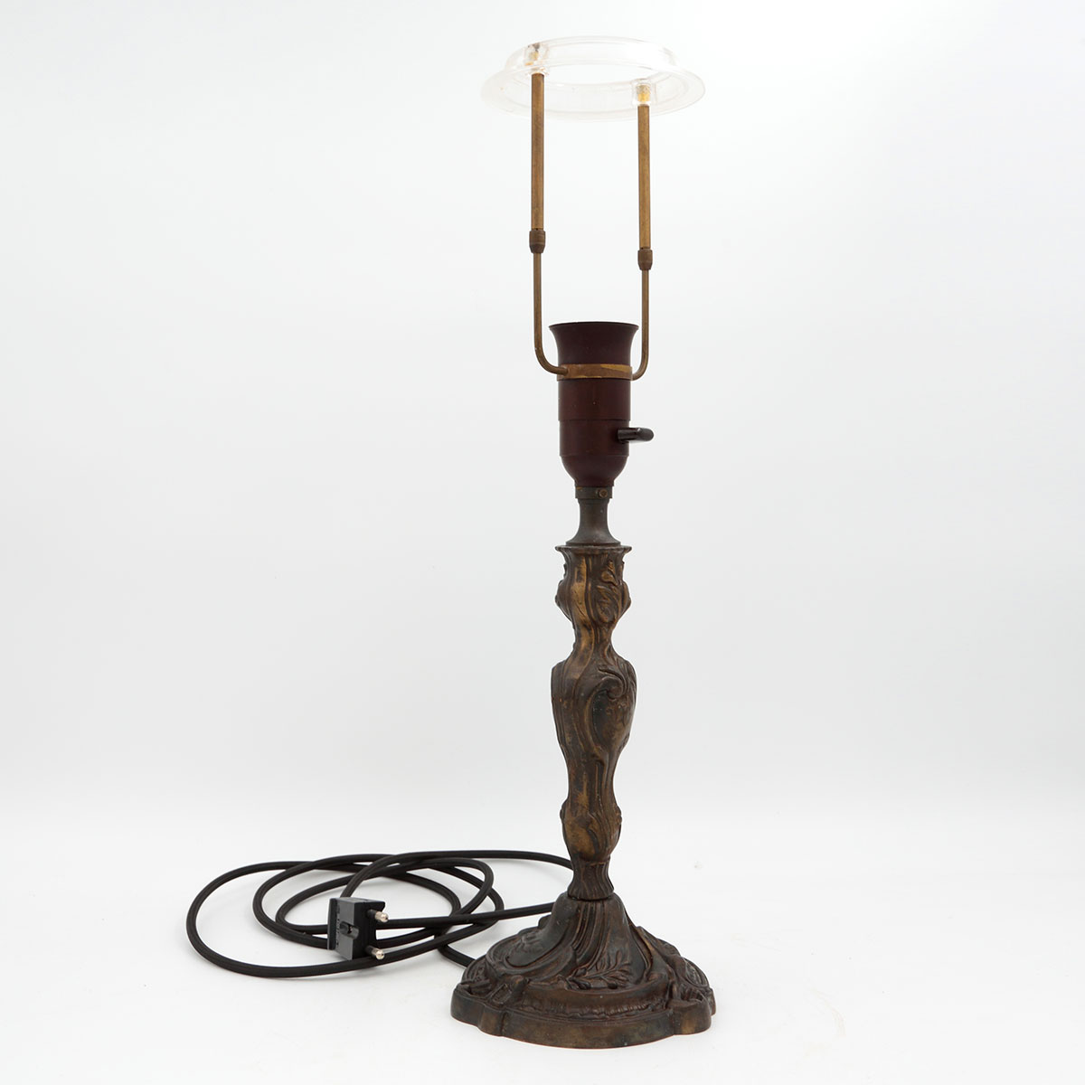 Antik fransk bordlampe i rokokostil med svungent bladværk, mørk patina og brun bakelitfatning.