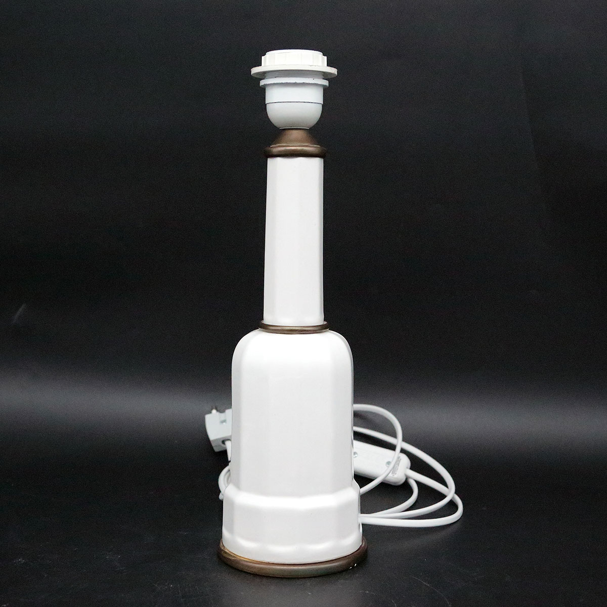 Elegant Heiberg bordlampe med slank hals, hvid porcelænsfod og varme messingdetaljer.