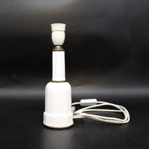 Heiberg bordlampe i hvidglaseret porcelæn med messingdetaljer og naturlig patina.