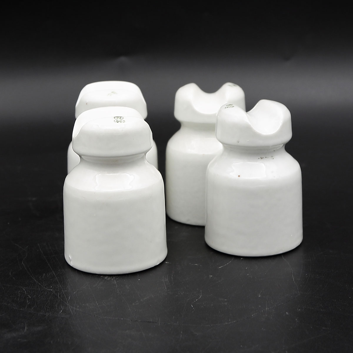 Originale hvide porcelænsisolatorer fra Norden med grønt N-stempel og årstal på toppen.
