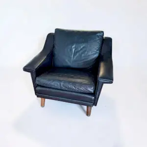 Vintage lænestol i mørkt læder med brede armlæn, teakben og lækker patina.